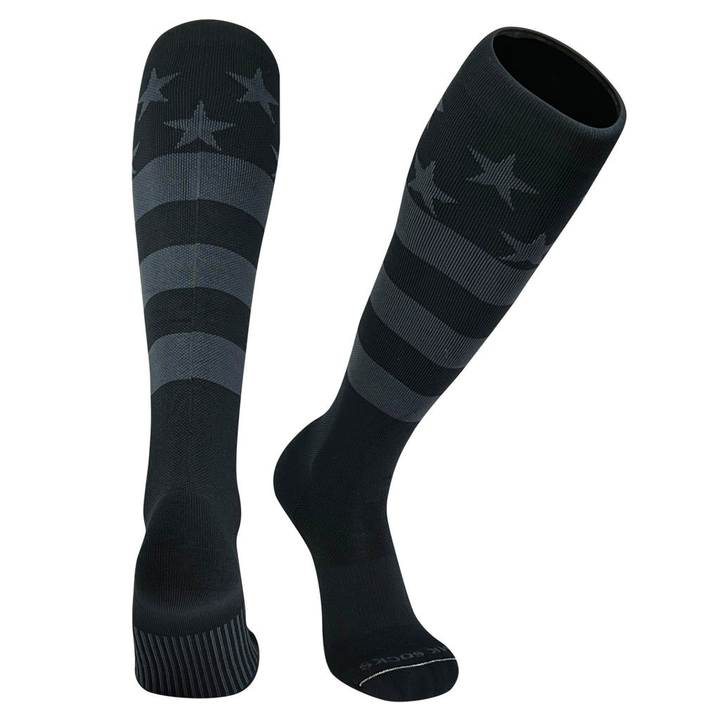 A pair of knee-high long sports socks with a USA flag design in black and graphite colors featuring stars and stripes.